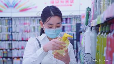 戴口罩的青年女人在超市选购洗护用品